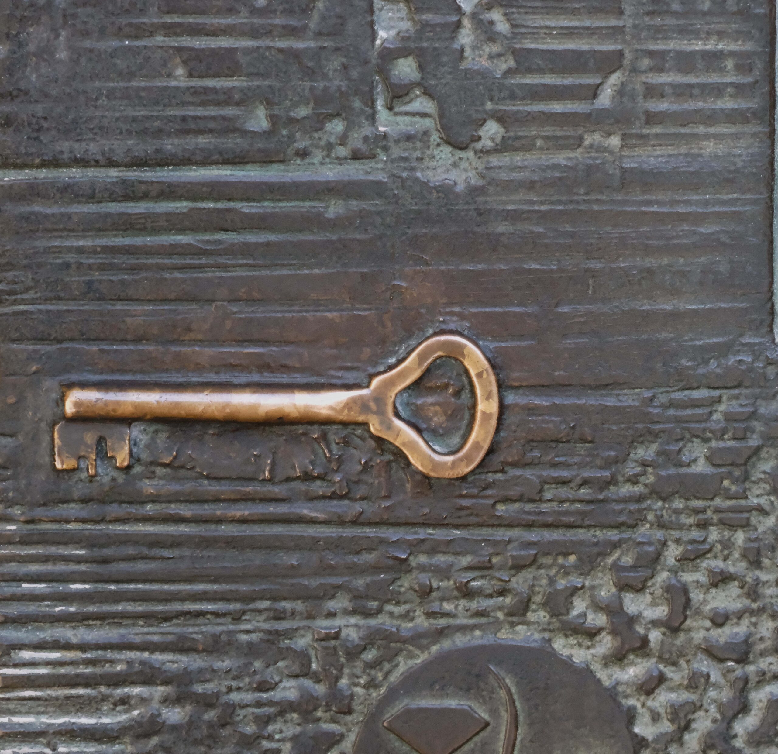 clé en or sur fond porte bois